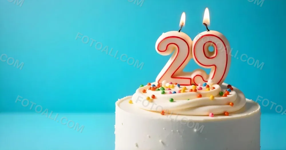 A Cake With White Frosting And Colorful Sprinkles Topped With A Candle In The Shape Of The Number 29 Blue Background 30 554f