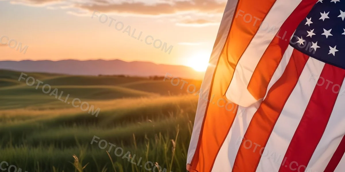 A Close Up View Of An American Flag Against A Scenic Sunset Landscape With A Grassy Field And A Bright Orange Sky 21 Fd31
