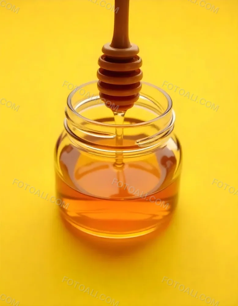 A Jar Full Of Honey With A Honey Dipper On A Yellow Background 21 F9bd