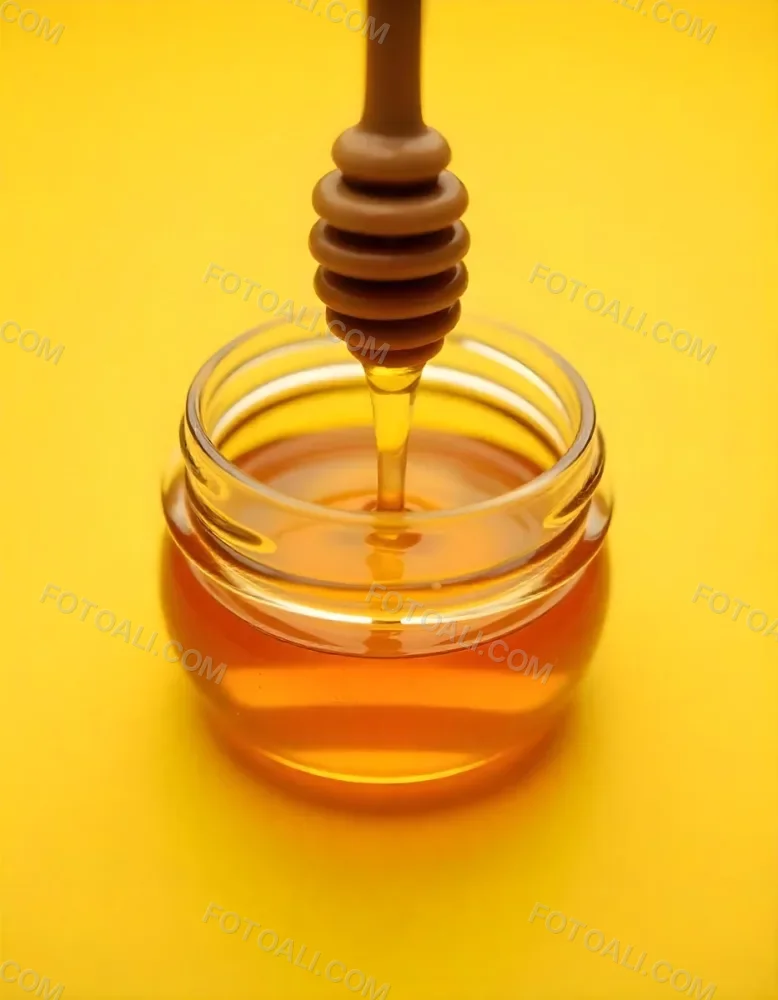 A Jar Full Of Honey With A Honey Dipper On A Yellow Background 23 831f