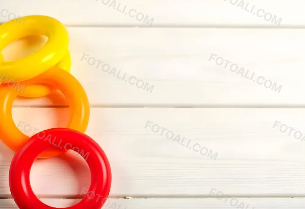 A Red Yellow And Orange Stacking Ring Toy On A White Wooden Surface The Rings Are Plastic And Shiny Close Up Shot 19 71a9