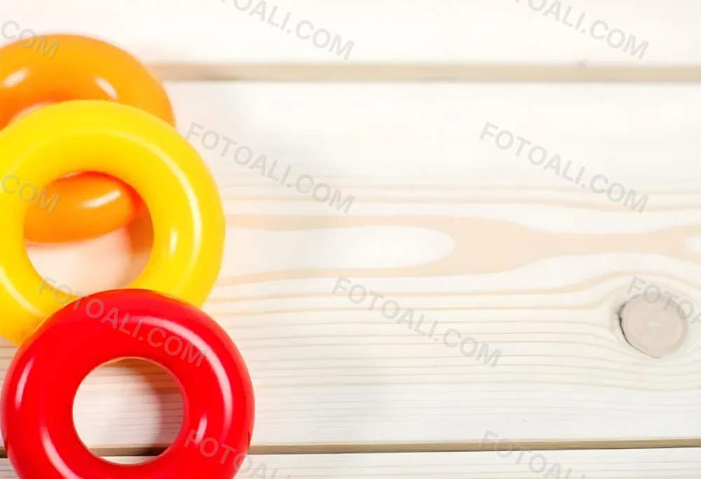A Red Yellow And Orange Stacking Ring Toy On A White Wooden Surface The Rings Are Plastic And Shiny Close Up Shot 45 7ce1