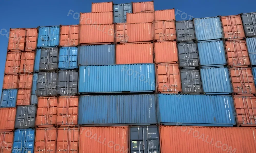 A Stack Of Blue Shipping Containers Arranged In A Staggered Formation Against A Clear Blue Sky Creating A Sense Of Industrial Scale And Logistical Complexity 10 38f8