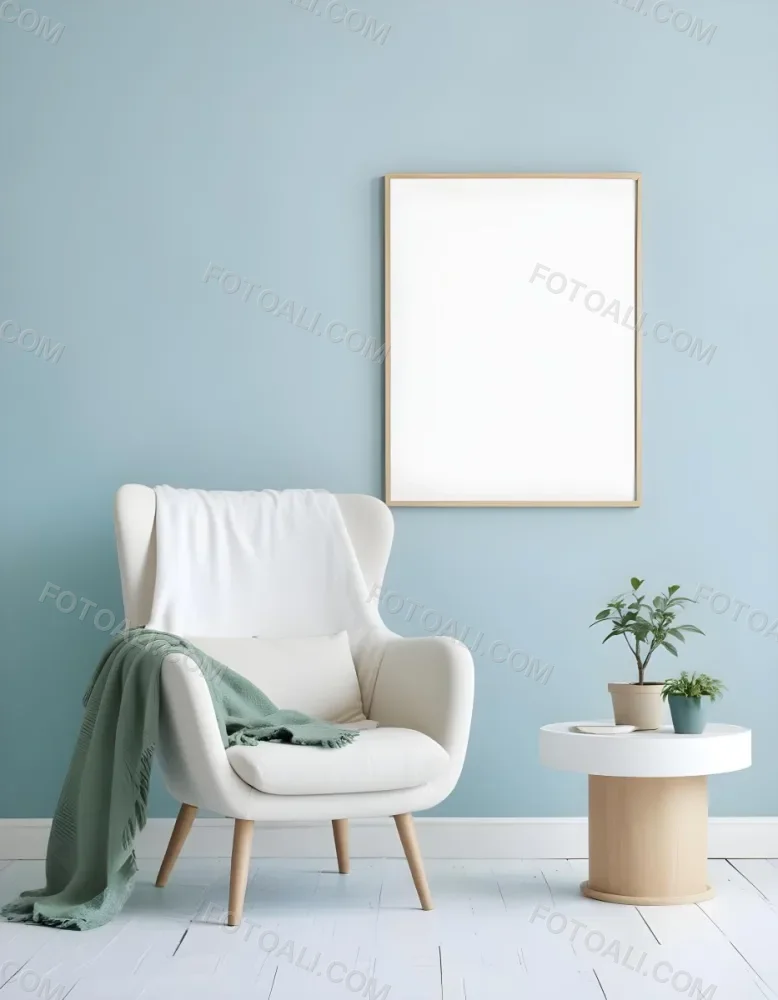 A White Armchair With A Blue Blanket Draped Over It A Small Side Table With A Potted Plant And A Blank White Frame On A Green Wall 19 A28d