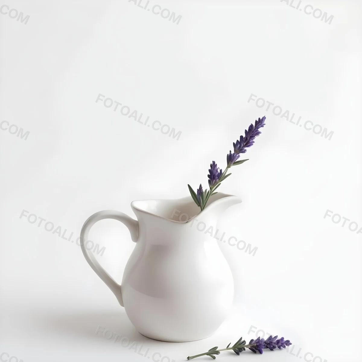 A White Ceramic Pitcher With A Sprig Of Lavender In It Another Sprig Of Lavender Is Lying On The White Surface 15 B379