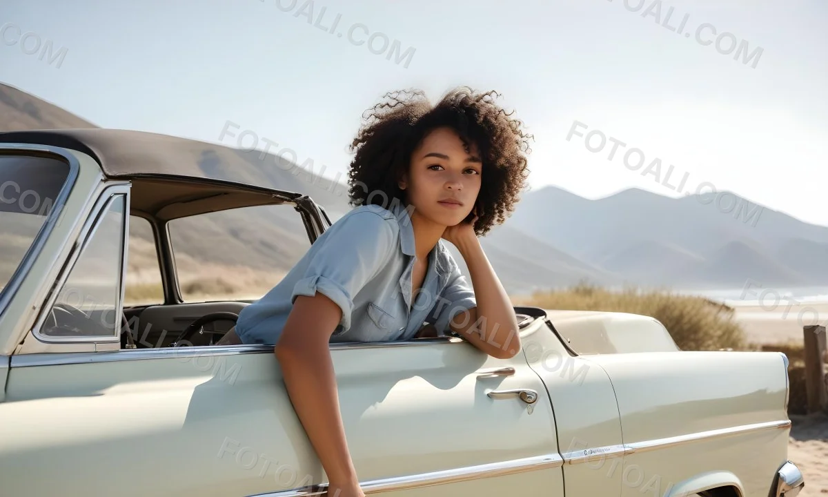 A Young Black Woman With Curly Hair Looking Out The Window Of A Vintage Car On A Sunny Beach With Mountains In The Background 2 A58a