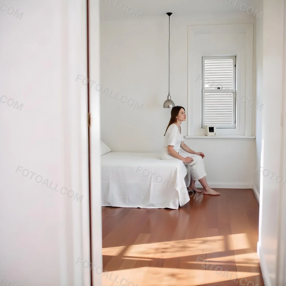 A Young Caucasian Woman With Long Brown Hair Sitting On A Bed 23 003e