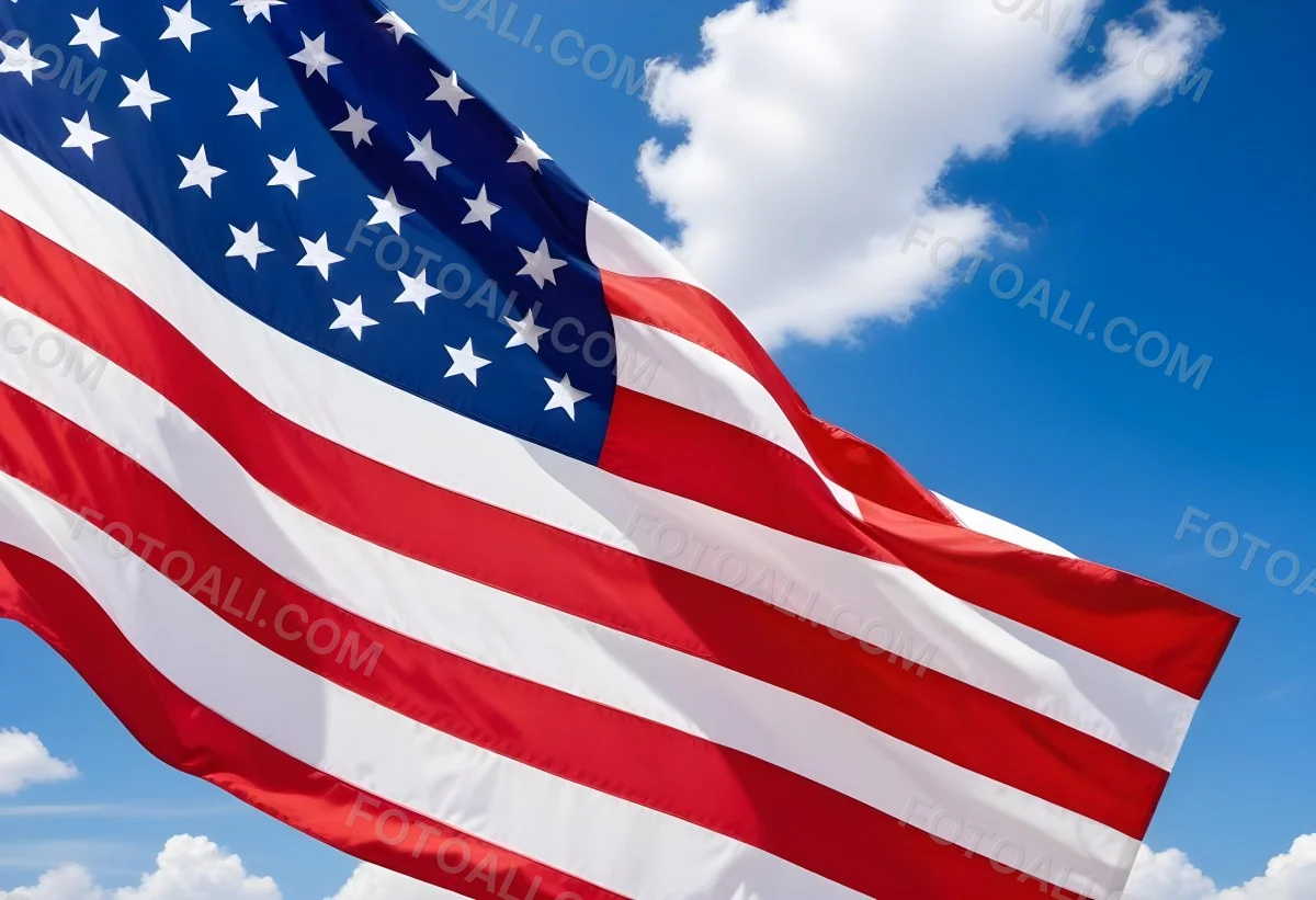 American Flag Waving In The Wind With Its Red And White Stripes And Blue Field Of Stars Against A Blue Sky With White Clouds 29 A398