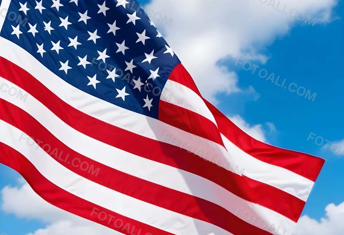 American Flag Waving In The Wind With Its Red And White Stripes And Blue Field Of Stars Against A Blue Sky With White Clouds 4 31f5