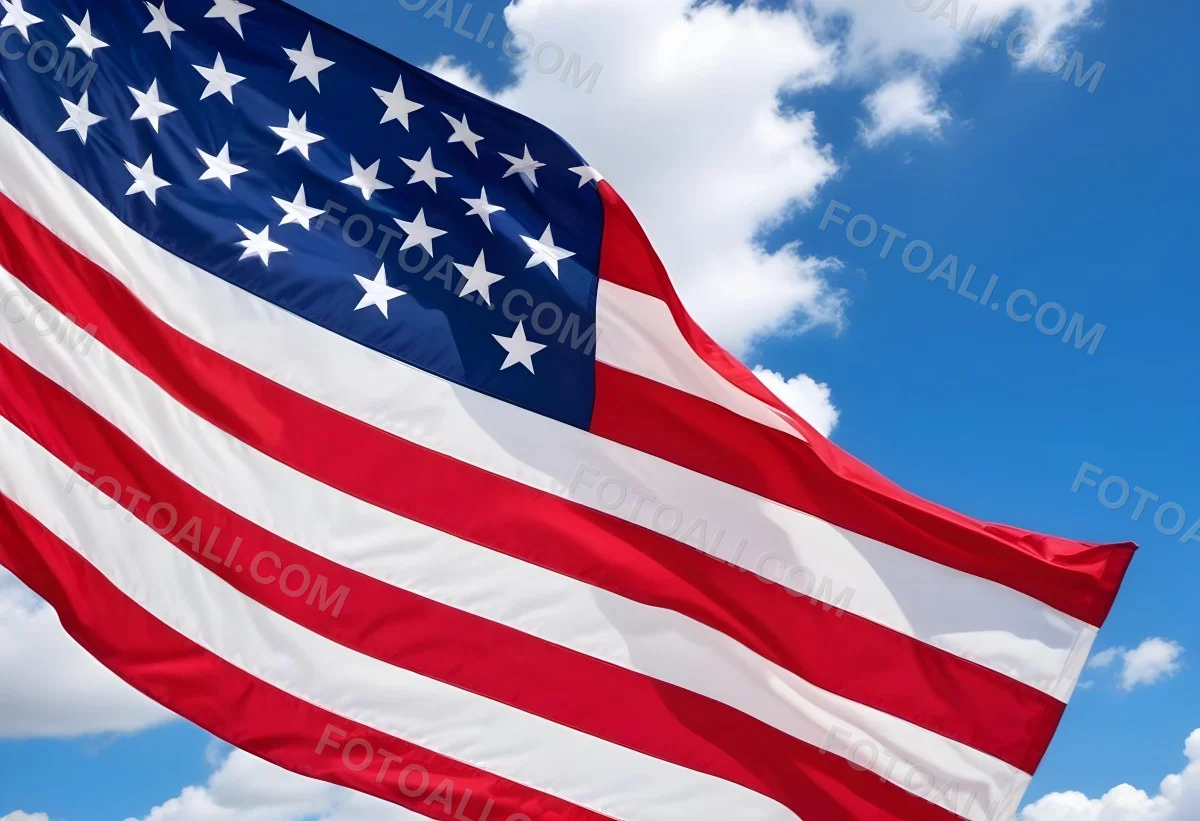American Flag Waving In The Wind With Its Red And White Stripes And Blue Field Of Stars Against A Blue Sky With White Clouds 5 Ea62