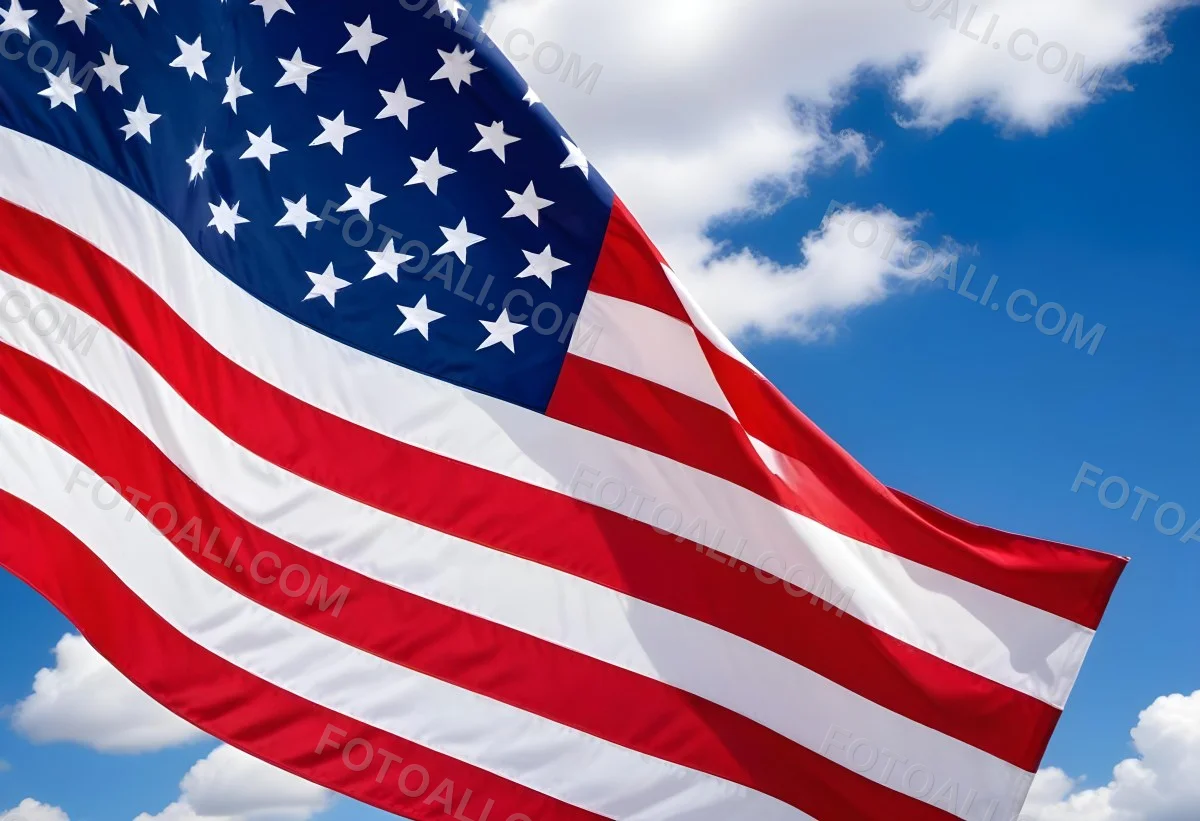 American Flag Waving In The Wind With Its Red And White Stripes And Blue Field Of Stars Against A Blue Sky With White Clouds 9 845b