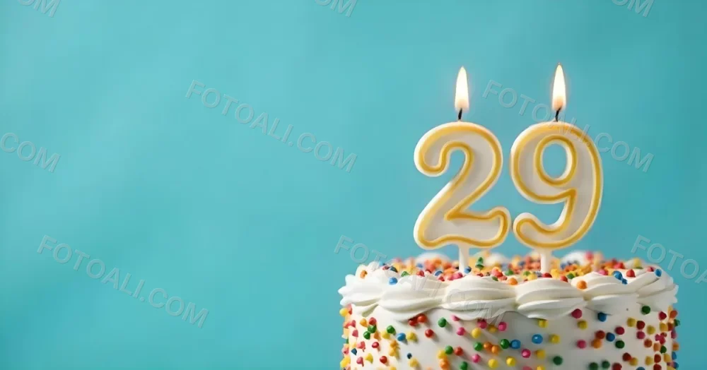 Birthday Cake With White Frosting And Colorful Sprinkles A Candle In The Shape Of The Number 29 Light Blue Background 17 134c