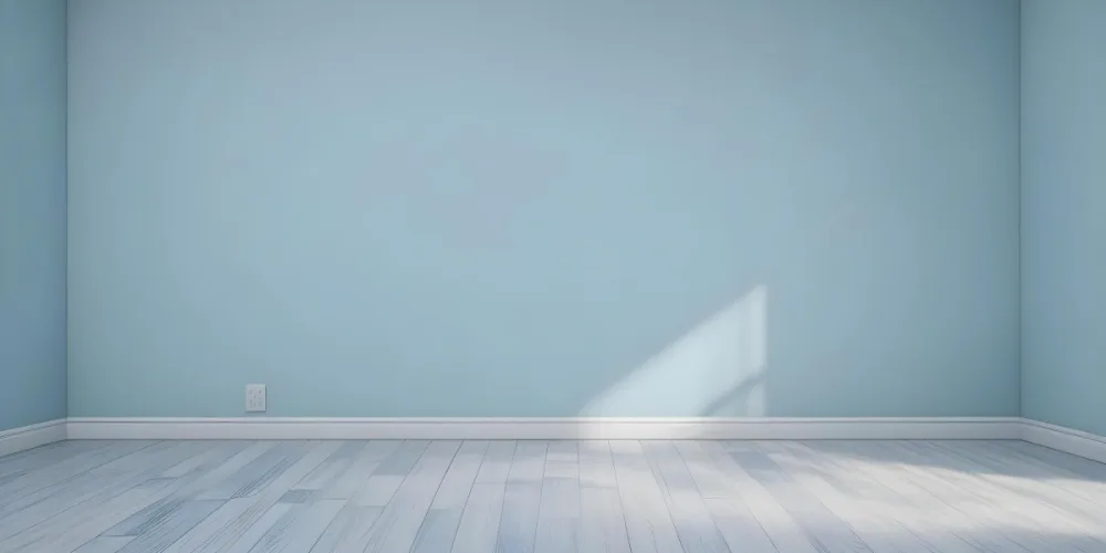 A Light Blue Wall With A White Baseboard And A Blue Wood Floor The Scene Is Illuminated With Soft Natural Light Simple And Clean 12 0493