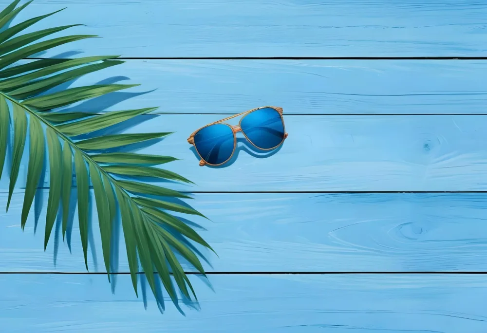 A Palm Leaf And Sunglasses On A Blue Wooden Surface Creating A Summery And Tropical Vibe Perfect For Vacation Or Beach Themed Designs 3 0770