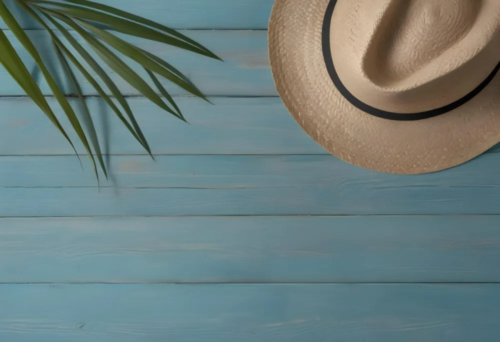 A Straw Hat And A Palm Leaf On A Blue Wooden Surface With Sand Creating A Summery And Beachy Vibe Top View 22 6812