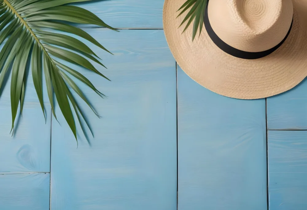 A Straw Hat And A Palm Leaf On A Blue Wooden Surface With Sand Creating A Summery And Beachy Vibe Top View 4 589c