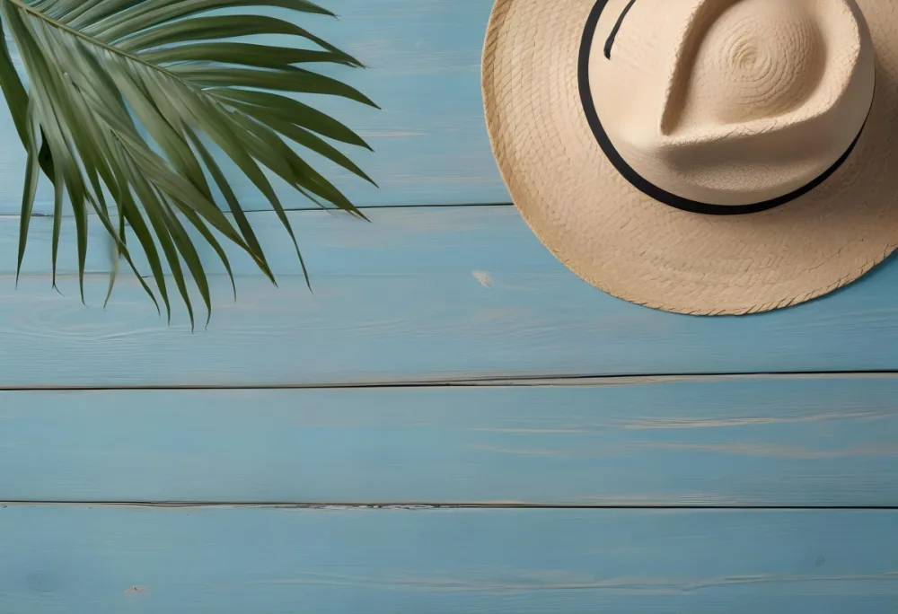A Straw Hat And A Palm Leaf On A Blue Wooden Surface With Sand Creating A Summery And Beachy Vibe Top View 48 29bc