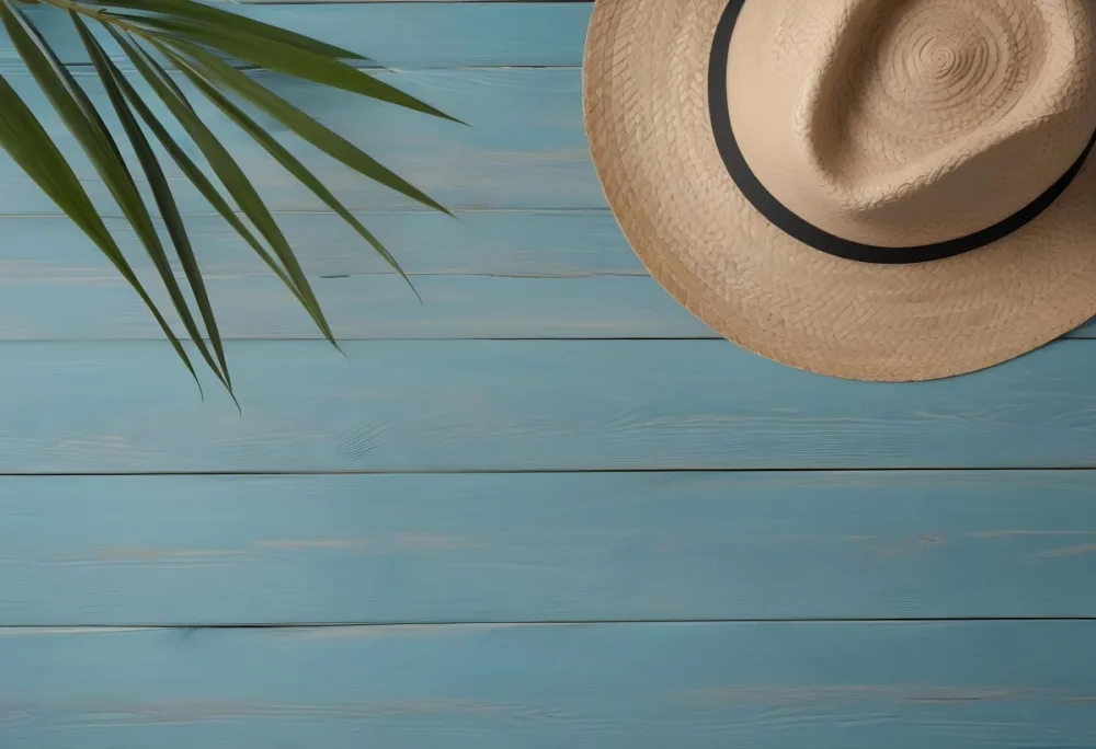 A Straw Hat And A Palm Leaf On A Blue Wooden Surface With Sand Creating A Summery And Beachy Vibe Top View 5 Ace7