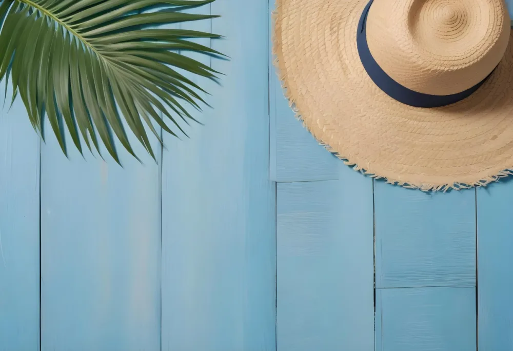 A Straw Hat And A Palm Leaf On A Blue Wooden Surface With Sand Creating A Summery And Beachy Vibe Top View 6 2ec4