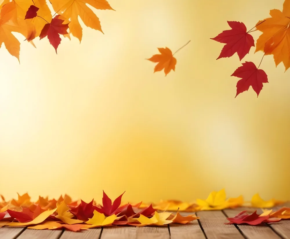 Colorful Autumn Leaves Falling On A Blurred Yellow And Orange Background With A Wooden Surface In The Foreground 20 1726