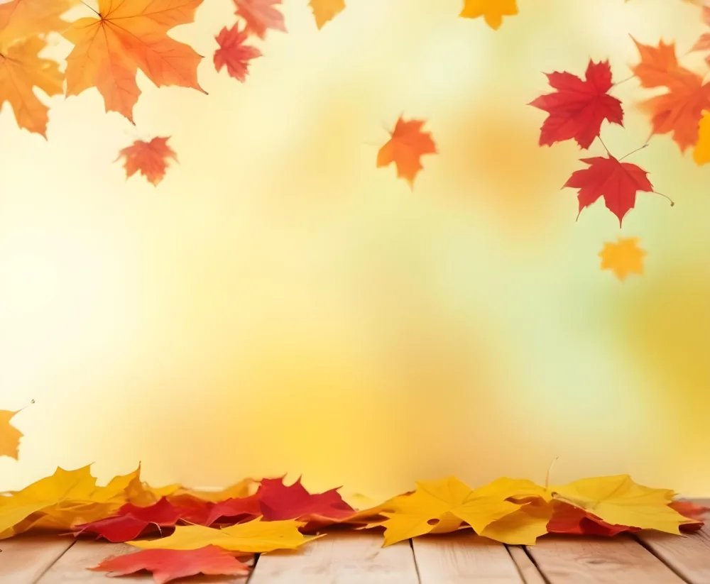 Colorful Autumn Leaves Falling On A Blurred Yellow And Orange Background With A Wooden Surface In The Foreground 27 75e0