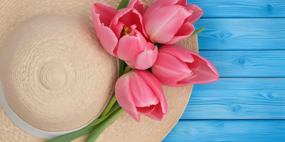 Pink Tulips On A Beige Straw Hat The Background Is A Blue Wooden Surface 19 E01e