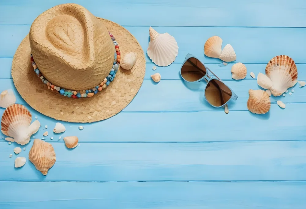 Straw Hat With A Beaded Band Seashells And Sunglasses Arranged On A Light Blue Wooden Surface Creating A Beach Vacation Theme 18 D299