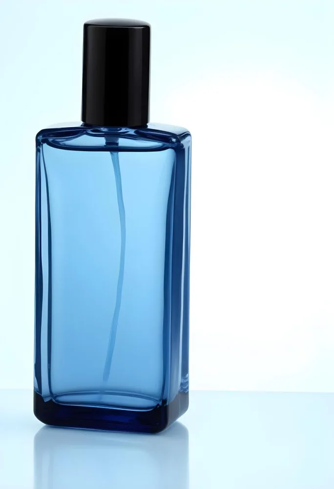 A Blue Glass Perfume Bottle With A White Cap Filled With A Blue Liquid On A Black Background 7 B0ce