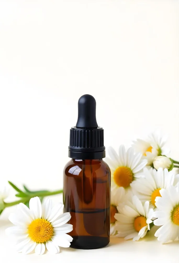 A Bottle Of Yellow Liquid Surrounded By White Daisy Flowers On A Light Background 11