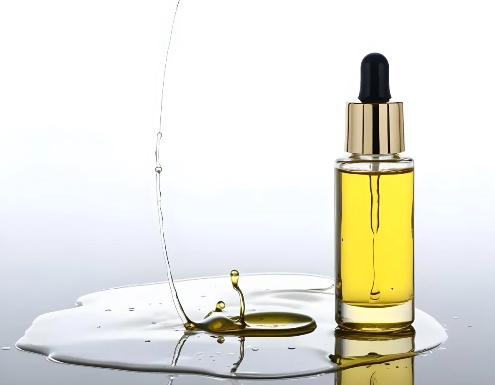 A Bottle Of Yellow Oil With A Dropper A Splash Of Oil On A White Surface And A White Background 15 1d3e