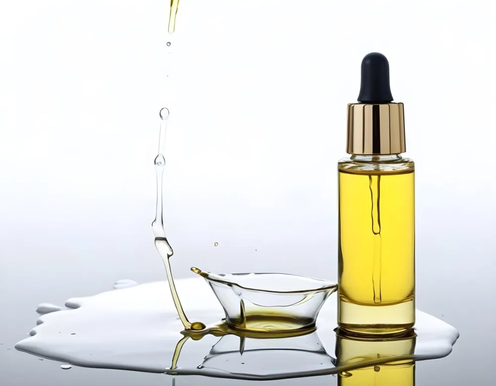 A Bottle Of Yellow Oil With A Dropper A Splash Of Oil On A White Surface And A White Background 2 E763