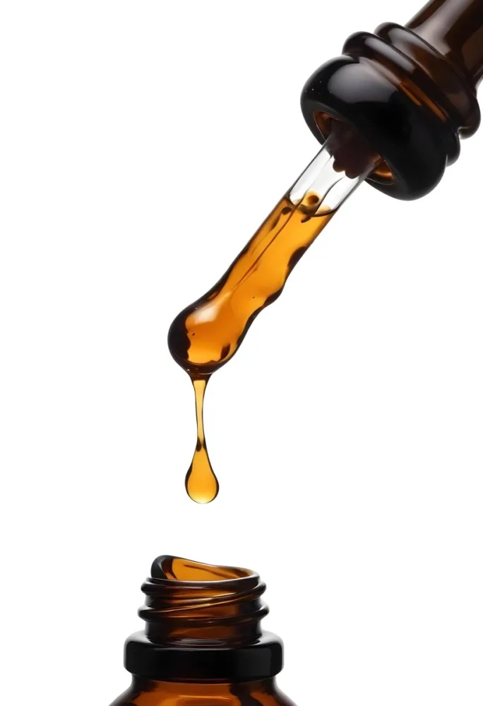 A Close Up Of A Dropper Filled With Amber Liquid Poised Above A Brown Glass Bottle Against A Stark White Background 1 7895