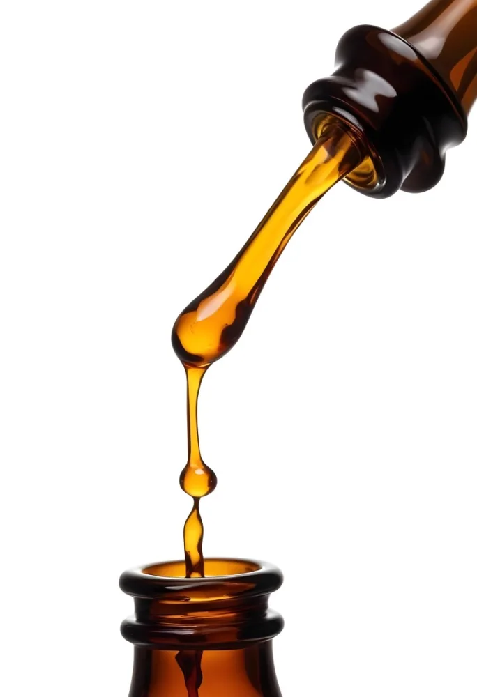 A Close Up Of A Dropper Filled With Amber Liquid Poised Above A Brown Glass Bottle Against A Stark White Background 11 F8a9