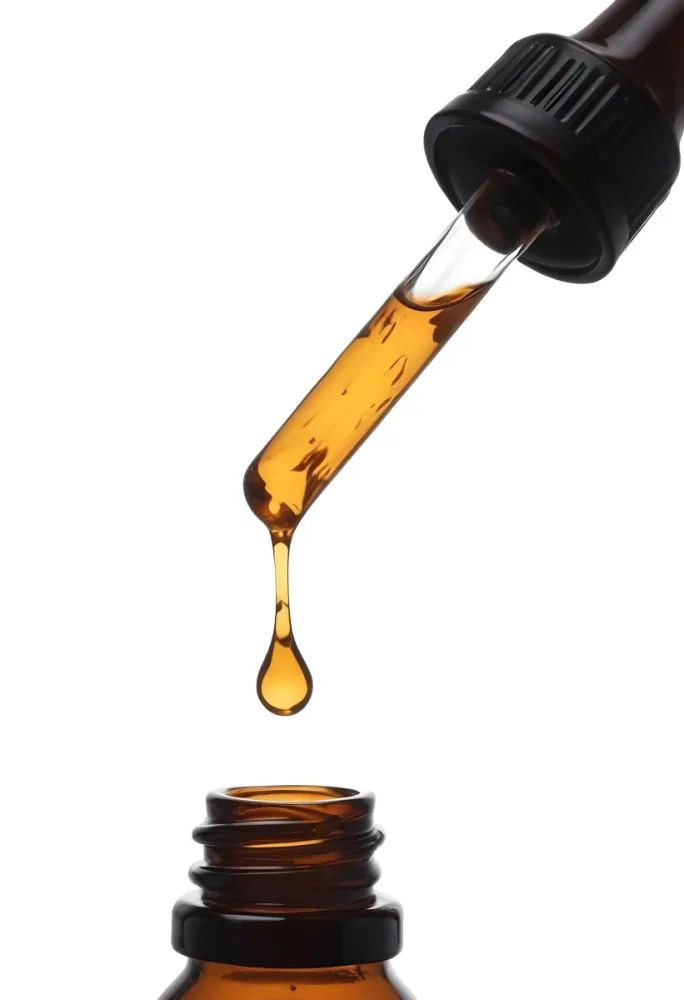 A Close Up Of A Dropper Filled With Amber Liquid Poised Above A Brown Glass Bottle Against A Stark White Background 20 5440
