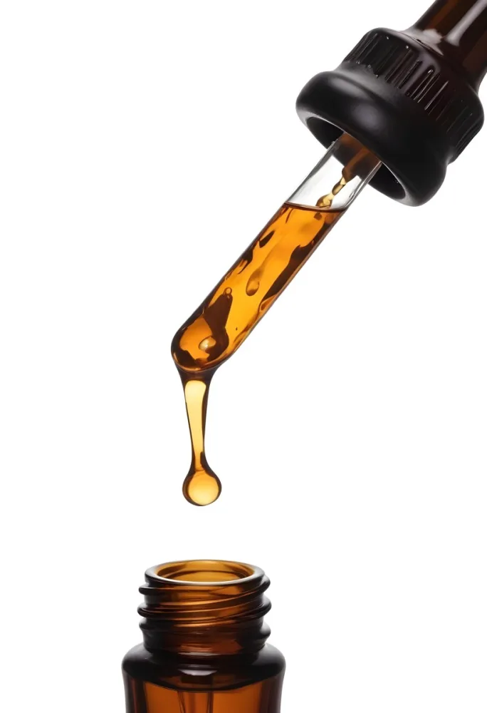 A Close Up Of A Dropper Filled With Amber Liquid Poised Above A Brown Glass Bottle Against A Stark White Background 33 A806