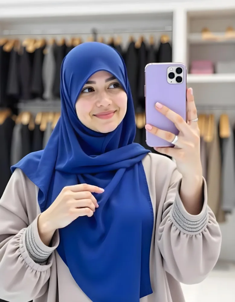 A Middle Eastern Woman 25 Years Old Light Skin With A Blue Hijab Taking A Selfie With A Purple Phone In A Clothing Store 39 75ac