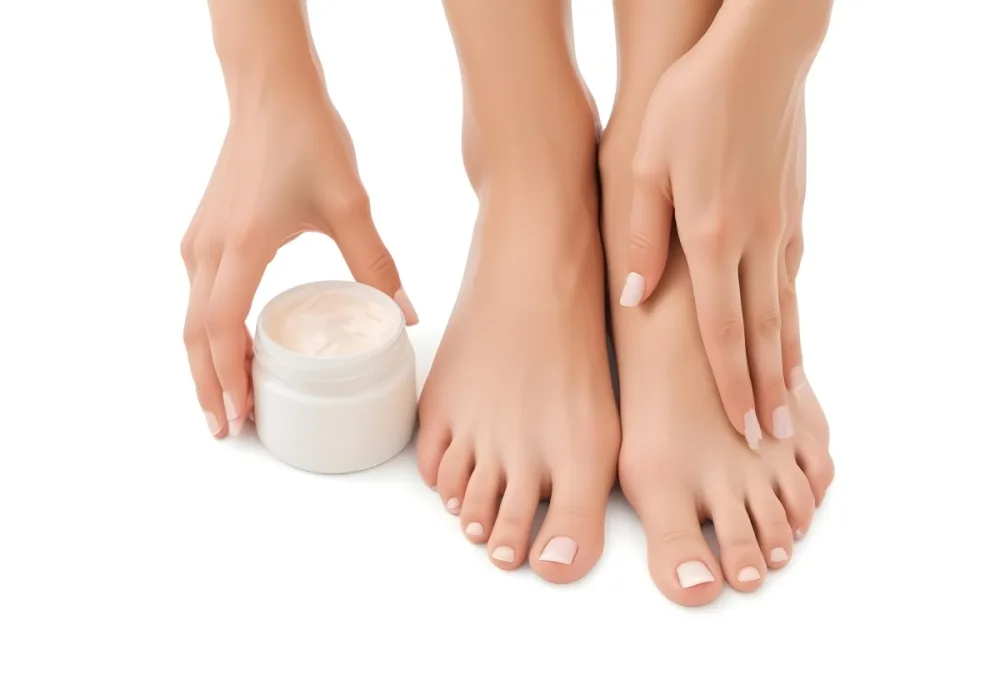 A Pair Of Woman S Feet With Fair Skin And A Hand Holding A White Jar With Cream On A White Background 1 Ea89