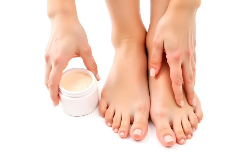 A Pair Of Woman S Feet With Fair Skin And A Hand Holding A White Jar With Cream On A White Background 10 0ddc