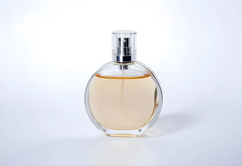 A Round Glass Perfume Bottle With A White Cap Filled With A Light Amber Liquid Centered On A Plain White Background Product Photography Studio Lighting 5 C819