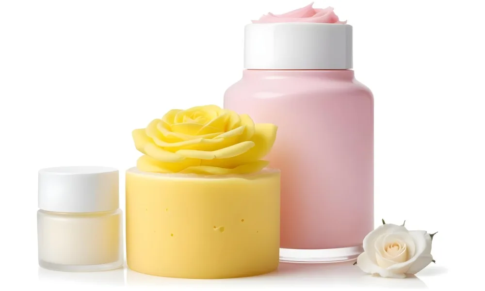 A Yellow Sponge Next To A Pink And White Cosmetic Cream Jar With A White Rose In A White Background 25 A157