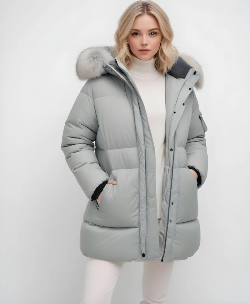 A Young Blonde Woman Wearing A Gray Puffer Jacket With A Large Fur Trimmed Hood Standing Against A White Background 18 4d74