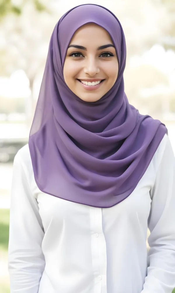 A Young Middle Eastern Woman With Dark Hair Wearing A Purple Hijab And A Light Colored Jacket Smiling In An Outdoor Setting With Trees In The Background 17 F8c7