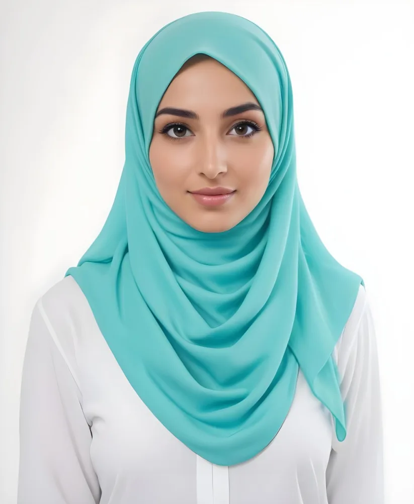 A Young Middle Eastern Woman With Dark Hair Wearing A Teal Hijab Looking Directly At The Camera With A Slight Smile In A Park During Daytime 10 A496