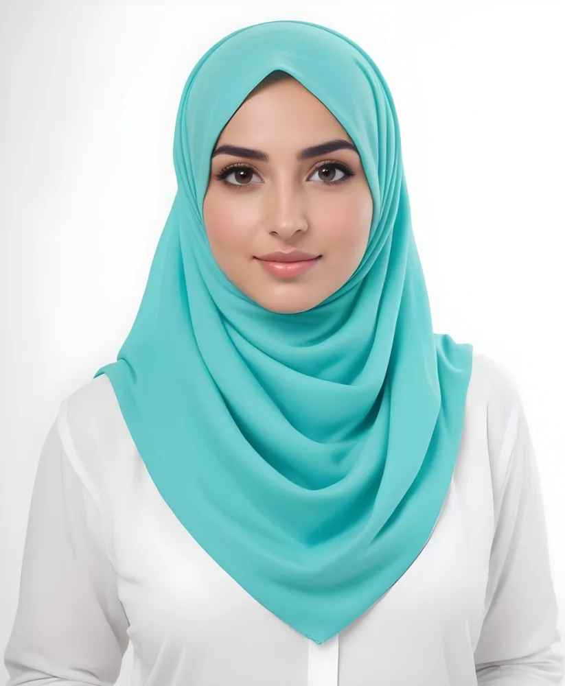 A Young Middle Eastern Woman With Dark Hair Wearing A Teal Hijab Looking Directly At The Camera With A Slight Smile In A Park During Daytime 11 2b27