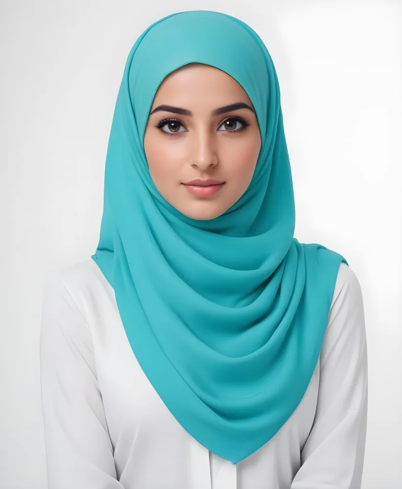 A Young Middle Eastern Woman With Dark Hair Wearing A Teal Hijab Looking Directly At The Camera With A Slight Smile In A Park During Daytime 3 Ef9a