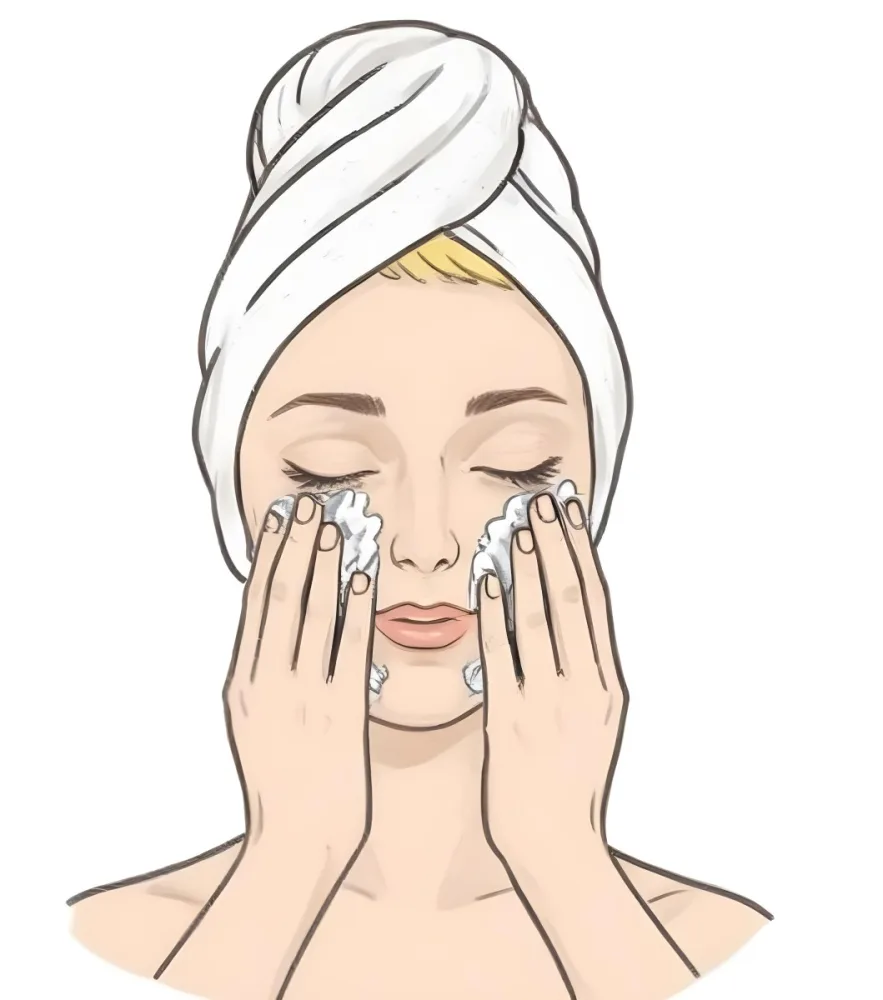 A Young Woman With Fair Skin And Short Blonde Hair Wearing A White Towel On Her Head Gently Washing Her Face With Her Hands In A Bright Bathroom 11 180f
