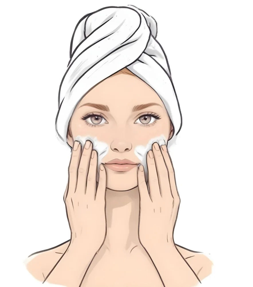 A Young Woman With Fair Skin And Short Blonde Hair Wearing A White Towel On Her Head Gently Washing Her Face With Her Hands In A Bright Bathroom 5 5e64