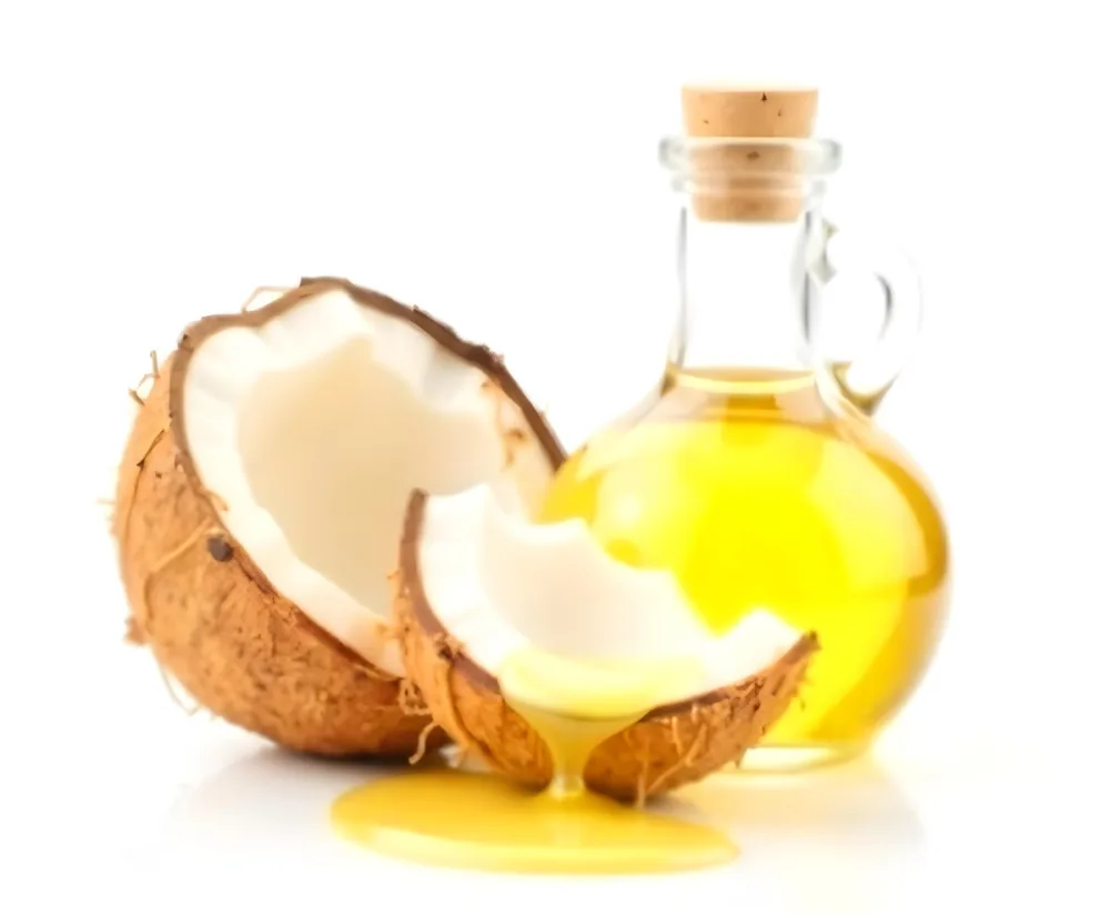 Coconut Oil Bottle With Cork Next To A Halved Coconut With Oil Dripping In A White Background 13 0ff5