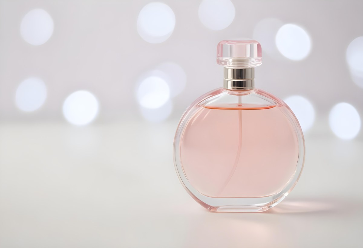 Round Perfume Bottle With A Transparent Cap Filled With A Light Pink Liquid On A White Surface With A Bokeh Background 14 065d