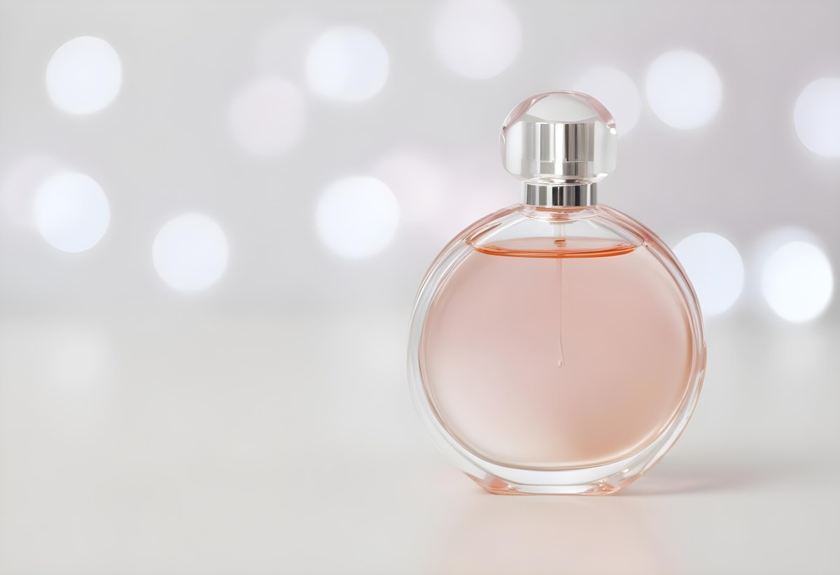 Round Perfume Bottle With A Transparent Cap Filled With A Light Pink Liquid On A White Surface With A Bokeh Background 18 6652